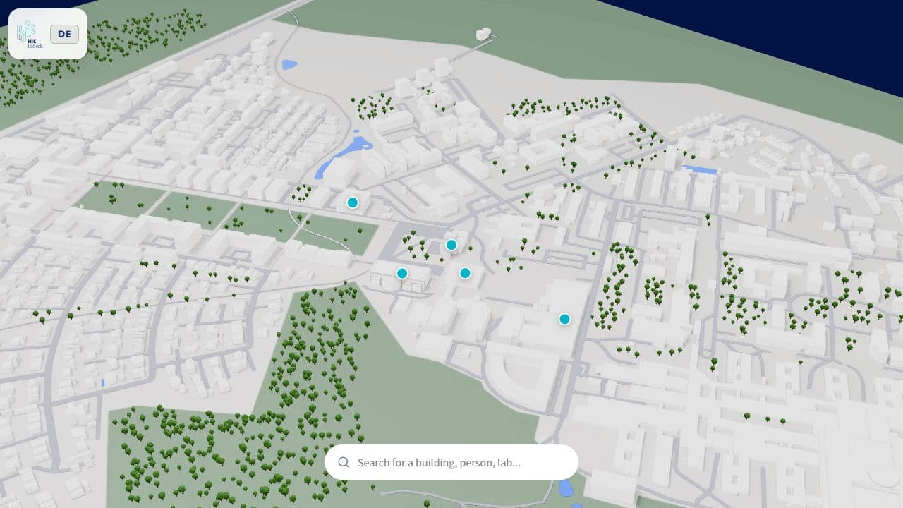 Overview of the Lübeck campus in the live 3D map, with white buildings, green trees and turquoise building markers.